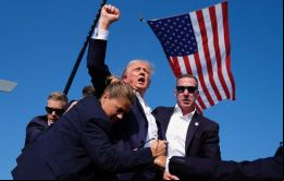 Trump se agachó detrás del atril mientras el personal de seguridad le protegía antes de volver a levantarse con el puño cerrado y dirigirse a la salida 
