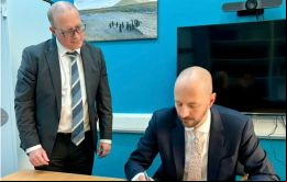 El Subdirector del Directorio de Territorios de Ultramar, Adam Pile OBE, firma los documentos en Casa de Gobierno, en Stanley capital de Falklands