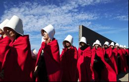 En el Parque de la Memoria, 32 mujeres vestidas con cofia blanca y vestido rojo, caminaron frente a los muros con los nombres de miles de víctimas de la dictadura