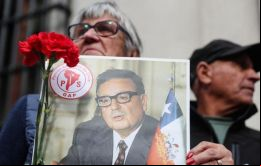 Una mujer sostiene un retrato en homenaje al presidente chileno Salvador Allende