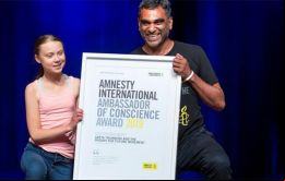 En la ceremonia de entrega del galardón, el secretario general de Amnistía Internacional, Kumi Naidoo y la joven activista sueca Greta Thunberg