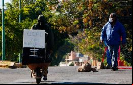 En tanto deudos se encontraban alrededor del ataúd, cubierto con plástico negro y sobre una carretilla, un letrero decía: “Q.E.P.D, siete días muerto por Covid” 