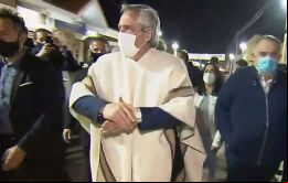  Enfundado en un poncho, y haciendo uso de un barbijo, el presidente Fernández se acercó a saludar a las personas que estuvieron esperando su llegada