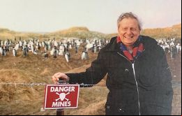 Harold Briley con un cartel de un campo minado en las Falklands